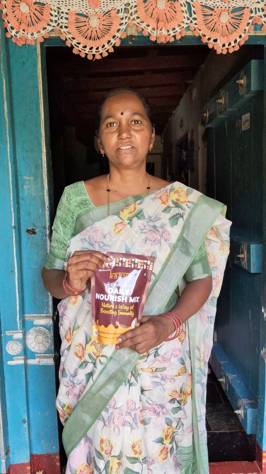 Rural woman holding Kaava Daily Nourish Mix